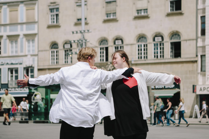 Eine junge Frau und ein junger Mann tanzen gemeinsam am Grazer Hauptplatz vor dem Rathaus