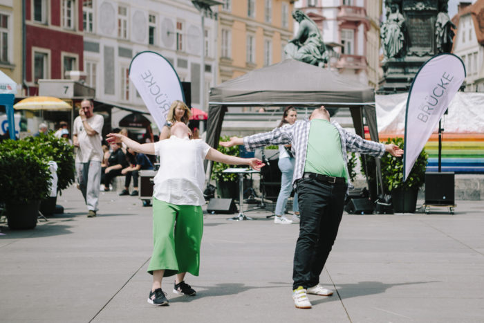 Eine junge Frau und ein junger Mann tanzen gemeinsam am Grazer Hauptplatz